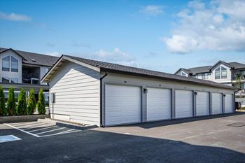 A row of garage doors in front of a house.